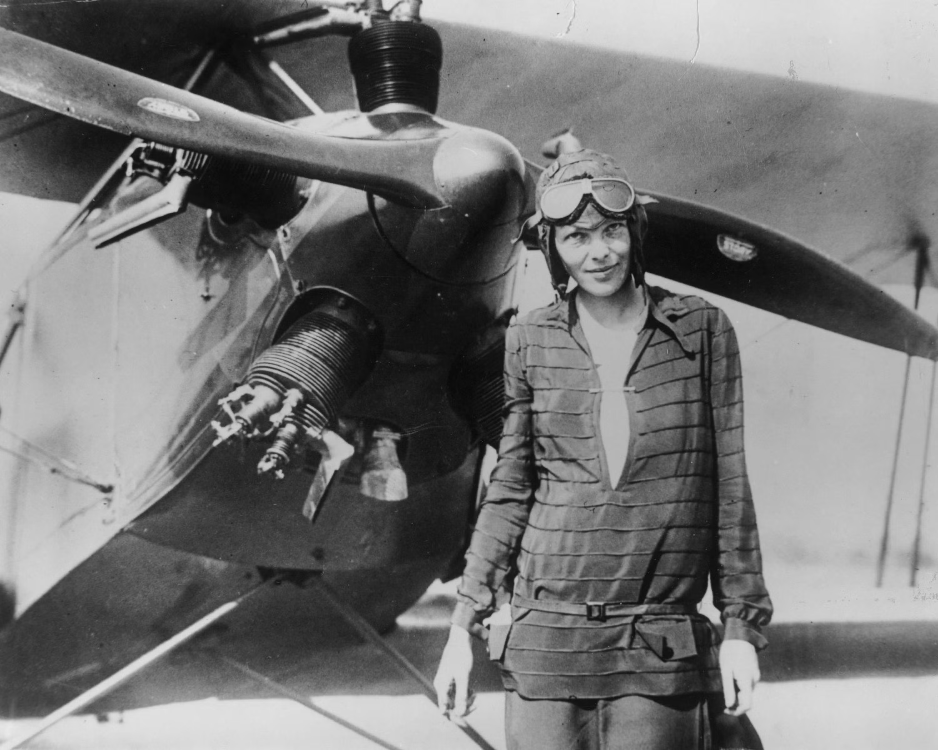 Amelia Earhart standing in front of her Lockheed Electra