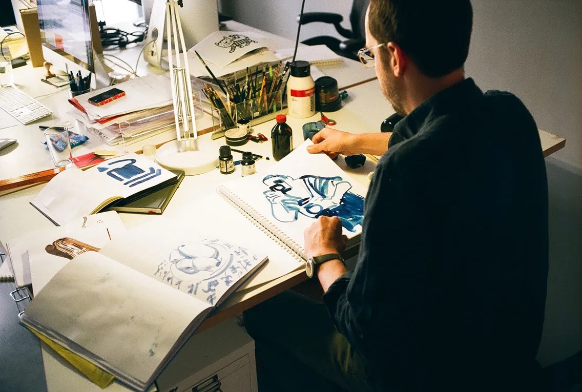 Christoph Niemann drawing at his desk in his studio