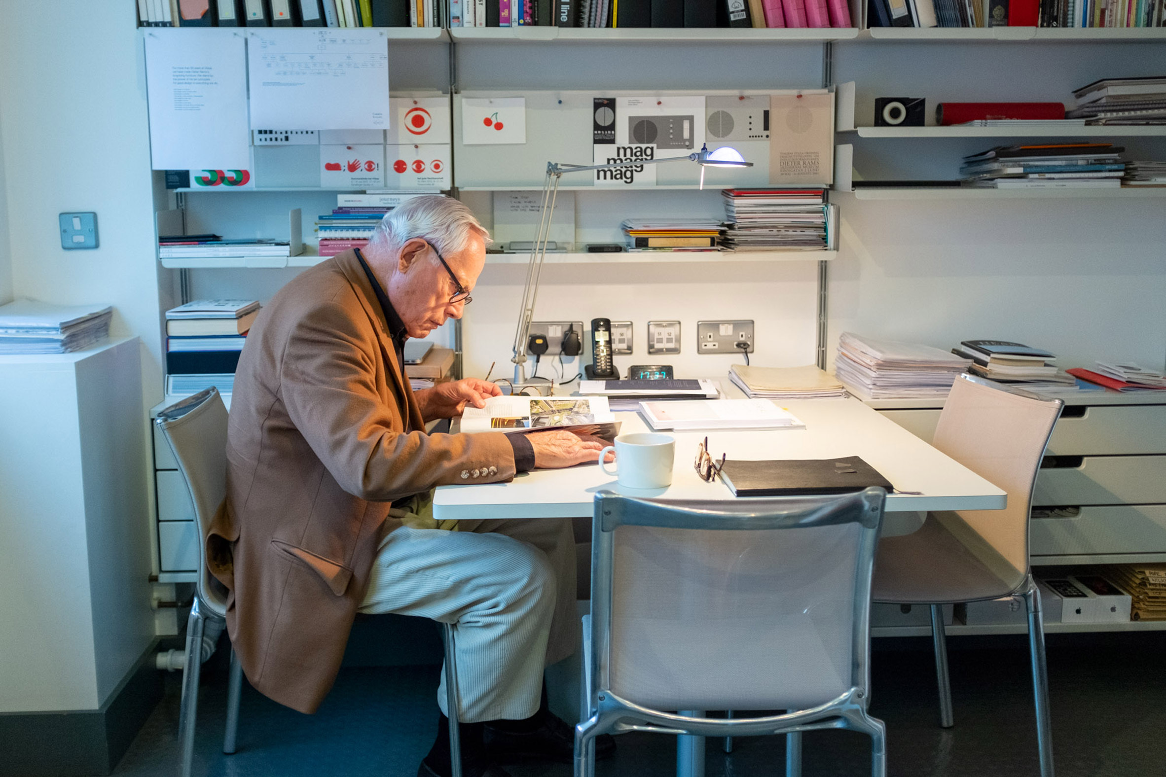 Dieter Rams studying product details at his desk at Braun
