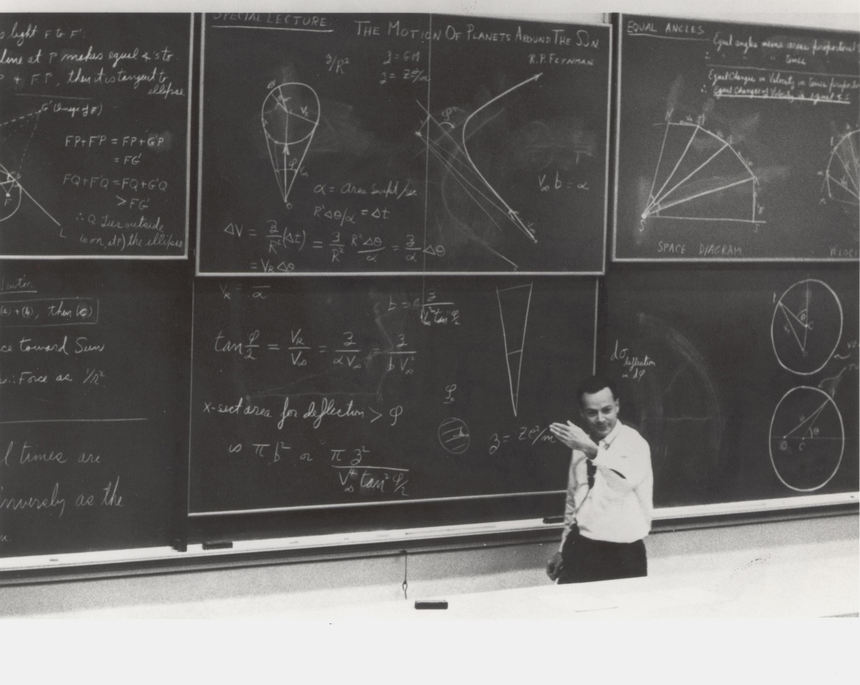 Richard Feynman lecturing at Caltech in front of chalkboards covered in physics